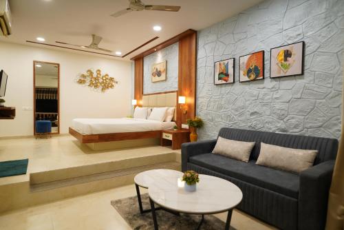 a hotel room with a bed and a couch and a table at Visava Amusement Park & Resort Navi Mumbai in Navi Mumbai