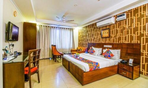 1 dormitorio con 1 cama y escritorio en una habitación en FabHotel SP Plaza Greater Kailash, en Nueva Delhi