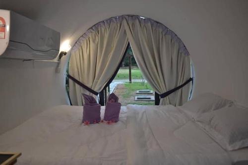 a little girl sitting on top of a white bed at Bagan Pinang Guest House in Port Dickson