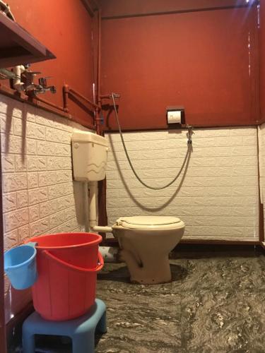 a bathroom with a toilet and a bucket at Ingawale farmhouse (agro tourism) in Satara
