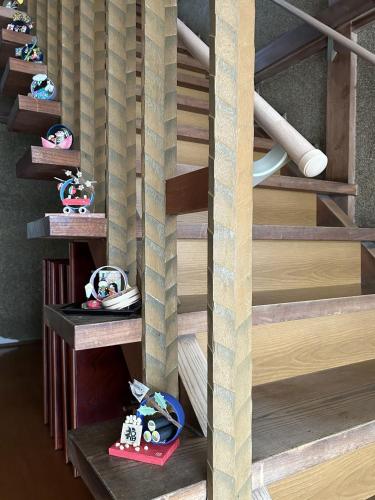 a spiral staircase with wooden steps with toys on them at 福寿苑　Fukujuen in Oshino