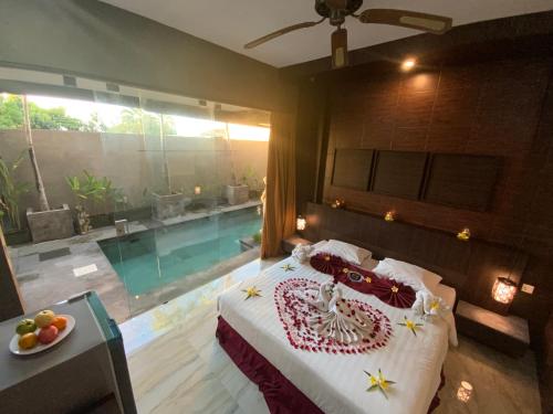 a bedroom with a bed and a swimming pool at Bali Golden Elephant Boutique Villa in Jimbaran