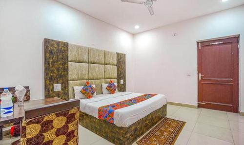 una camera con un grande letto e una porta in legno di FabHotel Grand Model Town Inn a Jalandhar
