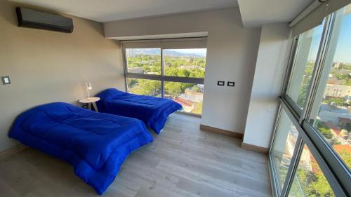 een kamer met twee blauwe banken en een groot raam bij Departamento de Película in Mendoza