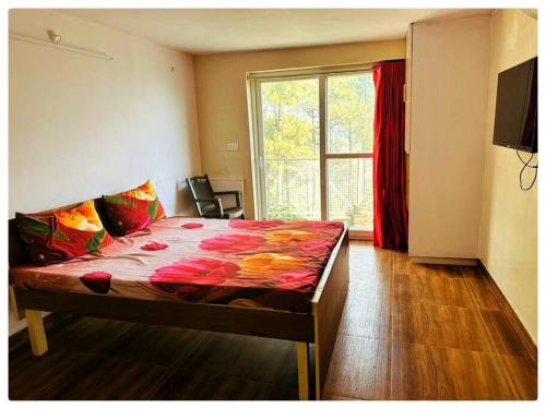 een slaapkamer met een groot bed en een groot raam bij 2 Bedroom Pine View Cottage with Lawn in Nainital