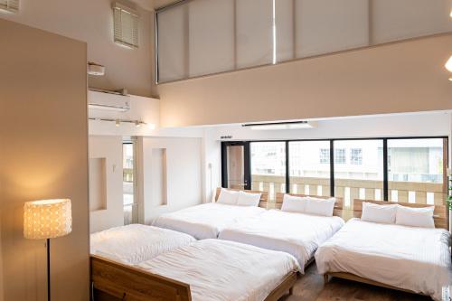 a row of beds in a room with windows at RIVER CENTRAL HIROSHIMA in Hiroshima