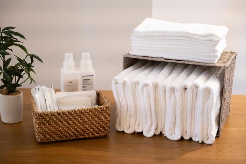 a basket filled with white towels and a bundle of towels at RIVER CENTRAL HIROSHIMA in Hiroshima