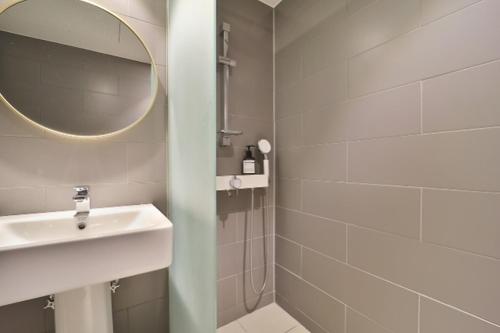 a bathroom with a sink and a shower with a mirror at Hotel Yam Yeonsan in Busan
