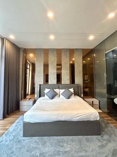 a bedroom with a large white bed with a blue rug at Khánh Nguyễn Luxury studio, balcony street view, large bathtub in Ho Chi Minh City