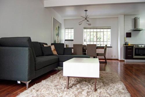 a living room with a couch and a table at Condesa Residence Amsterdam E Cozy Living Space in the Heart of the City on Amsterdam Avenue in Mexico City