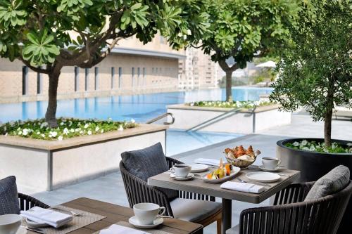 a table and chairs on a patio with a pool at EMAAR Residences Fashion Avenue - former Address Dubai Mall Residences by Qstay- Full Burj Khalfa Fountain view in Dubai