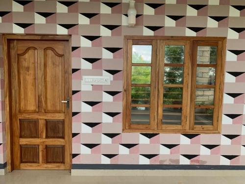 Zimmer mit einer karierten Wand und einer Tür in der Unterkunft Rajas Basera Homestay in Alappuzha