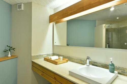 een badkamer met een wastafel en een spiegel bij Veranda Palmar Beach Hotel & Spa - All Inclusive in Belle Mare