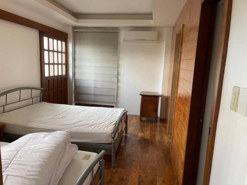 a bedroom with two beds and a wooden floor at Bagasbas House in Daet