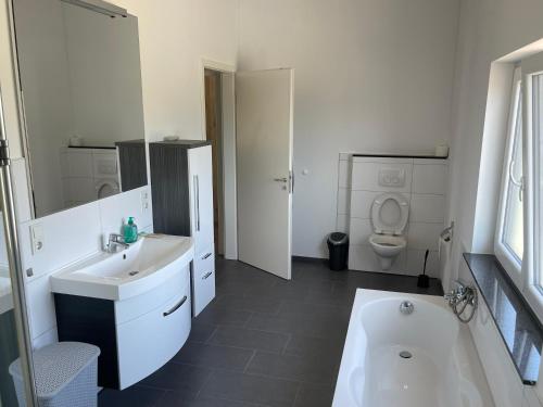 a white bathroom with a sink and a toilet at Penthouse Ob2 in Bad Essen