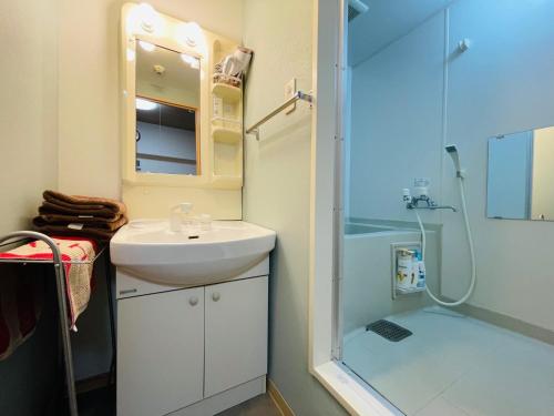 a bathroom with a sink and a shower at 新規OPEN札幌駅徒歩圏内10-1【サービスアパートメントSAPPORO札幌ステーション】 in Sapporo