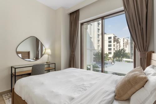 1 dormitorio con cama, espejo y ventana en Supreme Luxury 2BR Apartment en Dubái