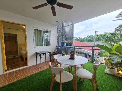 a patio with a table and chairs and a balcony at Hotel Pressie by SMS Hospitality in Panglao