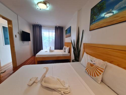 un dormitorio con una cama con un animal de peluche en Hotel Pressie by SMS Hospitality en Panglao
