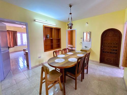 comedor con mesa de madera y sillas en Priyadeep BnB en Ooty