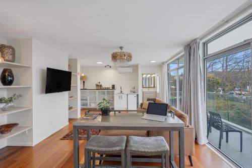 a kitchen and living room with a table with a laptop on it at The Bays Bed & Breakfast in Auckland