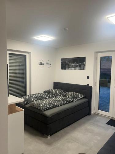 a bedroom with a black bed in a room at Schöne gemütliche Wohnung, Ferienwohnung in ruhiger Lage in Auerbach