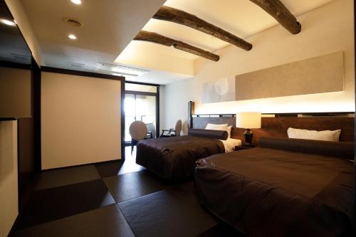 a hotel room with two beds and a projection screen at 海のほてる　いさば in Numazu