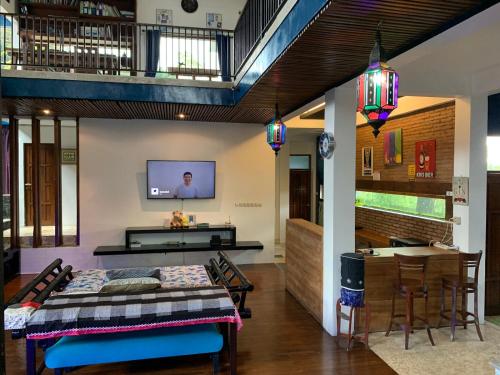 a room with a bed and a table and a tv at Griya Oma Nining-Large House with Swimming Pool in Bedoyo
