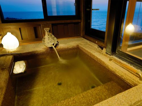a sink in a room with a view of the ocean at 海のほてる　いさば in Numazu