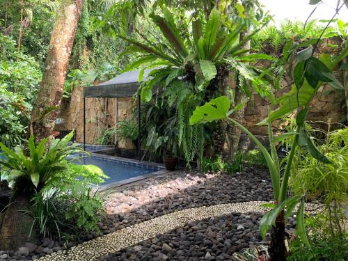 a swimming pool in the middle of a garden at Griya Oma Nining-Large House with Swimming Pool in Bedoyo