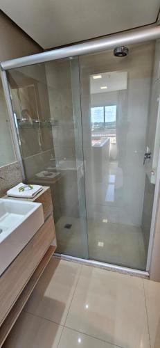 a bathroom with a glass shower and a sink at Flat confortável particular no Hotel Jade Park Sul Brasília-DF in Brasilia