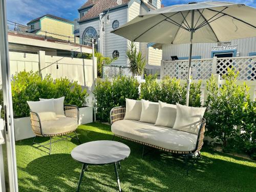 a patio with a couch and a table and an umbrella at Location, location, location! 10 steps to the beach in San Diego