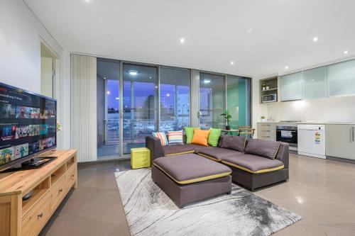 a living room with a couch and a flat screen tv at Strathfield sweet 2Br near Train StationShopping in Sydney