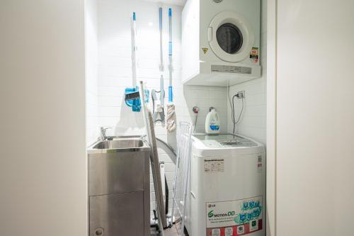 a medical room with a sink and a washing machine at Strathfield sweet 2Br near Train StationShopping in Sydney