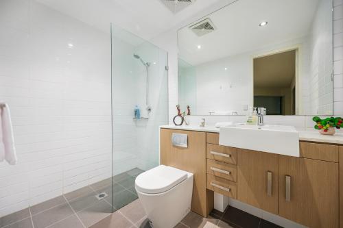 a bathroom with a toilet and a sink and a shower at Strathfield sweet 2Br near Train StationShopping in Sydney