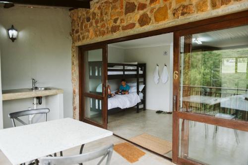 a child is sitting on a bed in a room at Matatane Camp - Babanango Game Reserve in Nkwalini