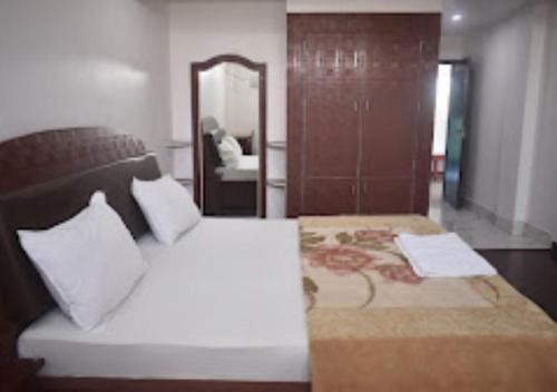 a bedroom with a large bed and a mirror at Hotel Midway & Zaika Restaurant Bihar in Madhipura