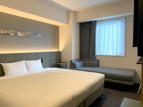 a hotel room with a bed and a window at hotel MONday Akihabara Asakusabashi in Tokyo
