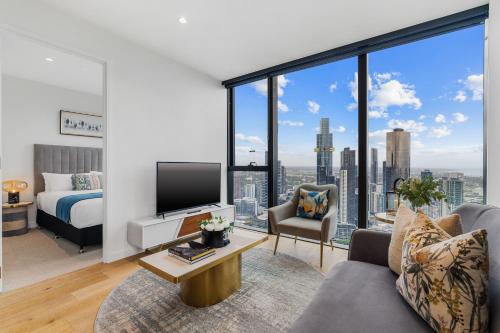 a living room with a bed and a large window at Collins House Apartments by CLLIX in Melbourne