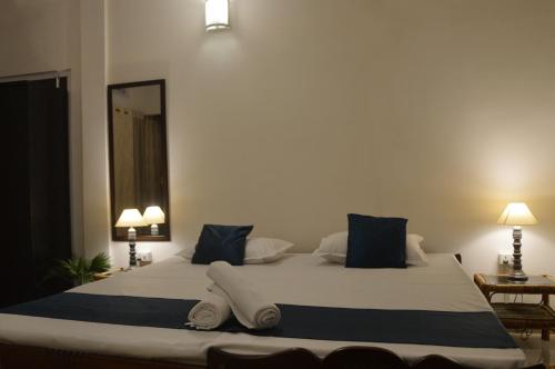 a bedroom with a large bed with blue and white pillows at Upaja Ghar Homestay in Guwahati