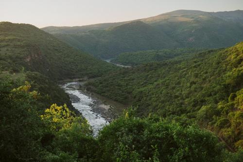 a view of a river in a valley with mountains at Matatane Camp - Babanango Game Reserve in Nkwalini
