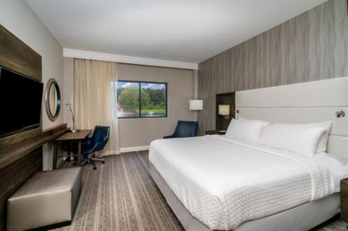 Habitación de hotel con cama, escritorio y TV. en Crowne Plaza Atlanta SW - Peachtree City, an IHG Hotel, en Peachtree City
