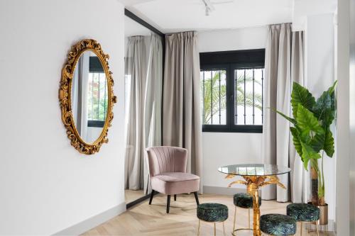 sala de estar con espejo, silla y mesa en Magno Apartments Zaragoza, en Sevilla