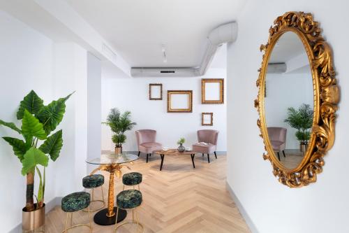 sala de estar con espejo y sillas en Magno Apartments Zaragoza, en Sevilla