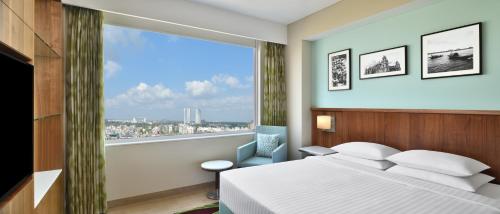 a bedroom with a bed and a large window at Fairfield by Marriott Kolkata in Kolkata