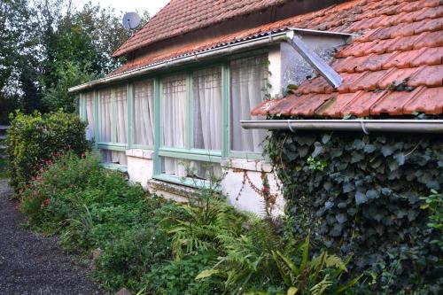 ein Haus mit einem roten Dach und einem Fenster in der Unterkunft cottage a la ferme in Lengronne