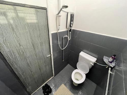 a bathroom with a shower and a toilet with a door at RH Homestay Mentakab-Temerloh. in Mentekab