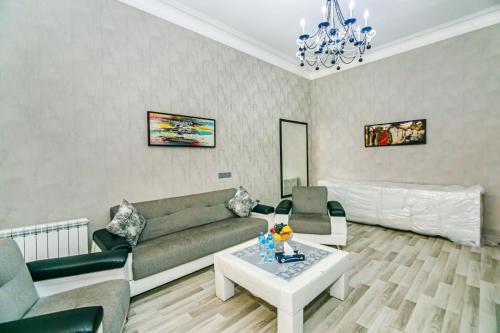 ein Wohnzimmer mit einem Sofa und einem Tisch in der Unterkunft Azneft Square Deluxe Apartment in Baku