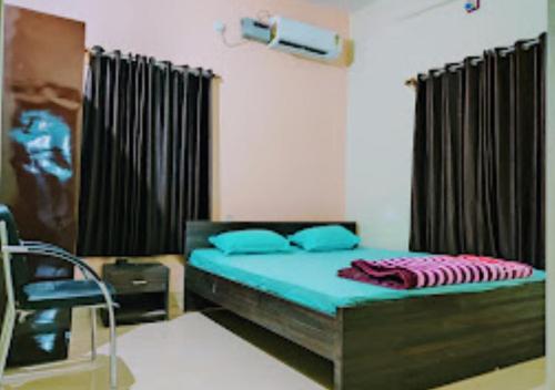 um quarto com uma cama e uma cadeira em Hotel Atithi Bihar em Madhipura