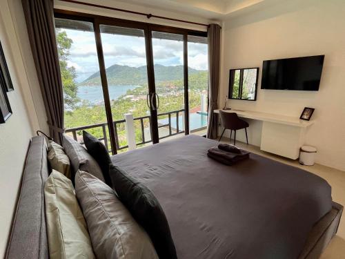 a living room with a couch and a large window at Harbour View Villa in Koh Tao